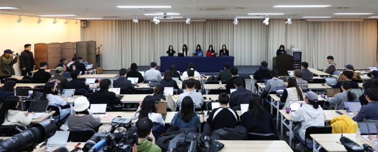 Reporters crowd a press conference held by NewJeans in Seoul, Friday. Yonhap